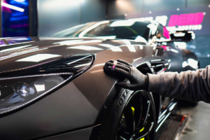 Wax is Dead ceramic coating Perth – Installer applying Ultimate Plus to a new vehicle in a state-of-the-art studio.