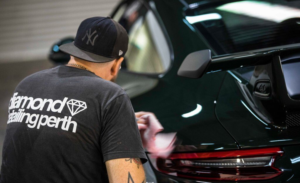 Diamond Detailing Perth technician applying ceramic coating to rear of green Porsche 911 GT3 RS in Perth studio